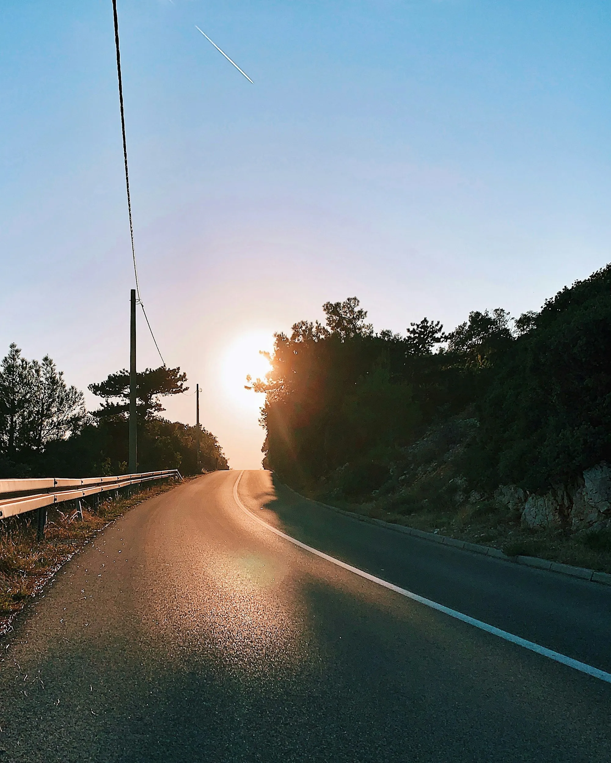 Hot sun setting over a winding road